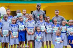 Distributing writing materials to primary school students in Nigeria